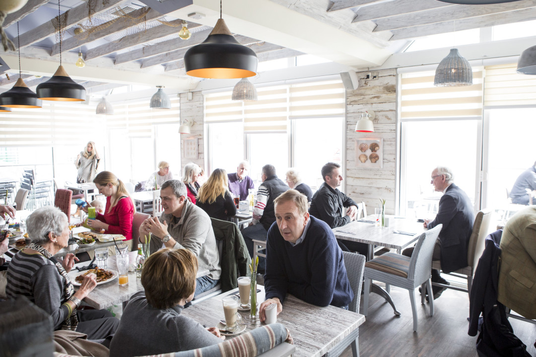 A group of people waiting for their meal while others are eating